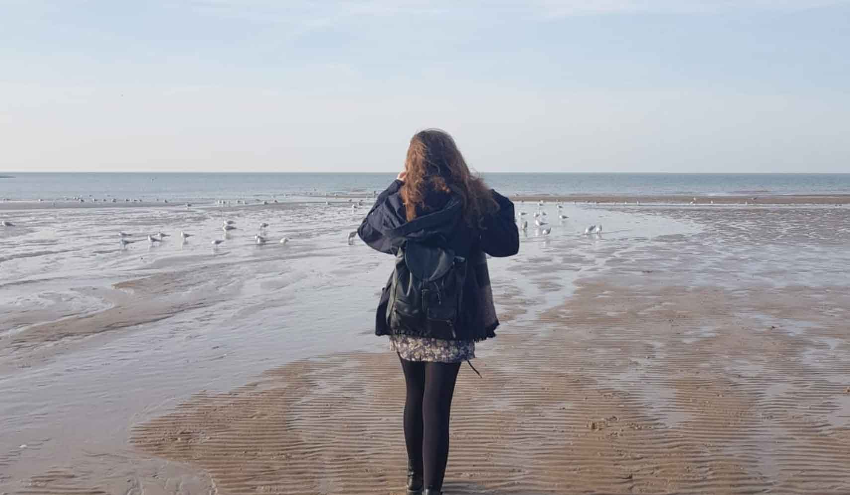 Student walking on a beach