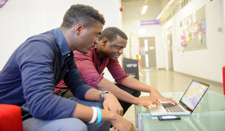 Two undergraduate male students looking at a laptop