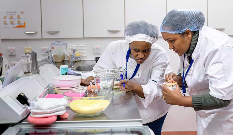 two students measuring ingredients