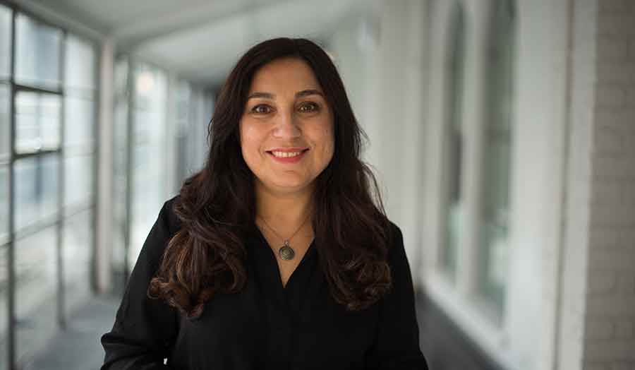 A faculty member standing in a corridor.