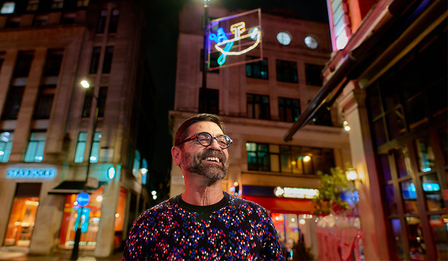 Antonio pictured under a christmas light in Soho