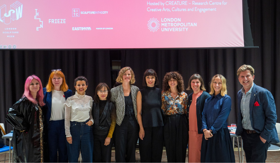 Group image of contributors in front of a projector on stage