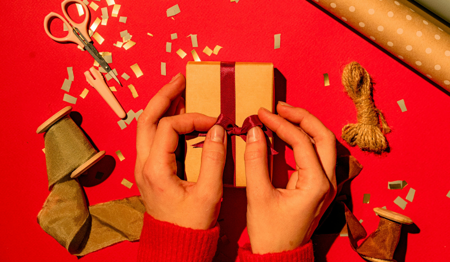 Hands tying a bow on a gift