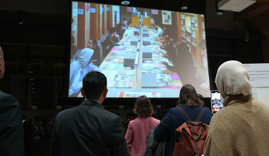 A group of people looking at a screen.