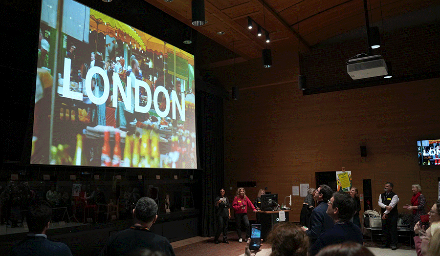 Three women presenting a slide with word 'London' written on a slide