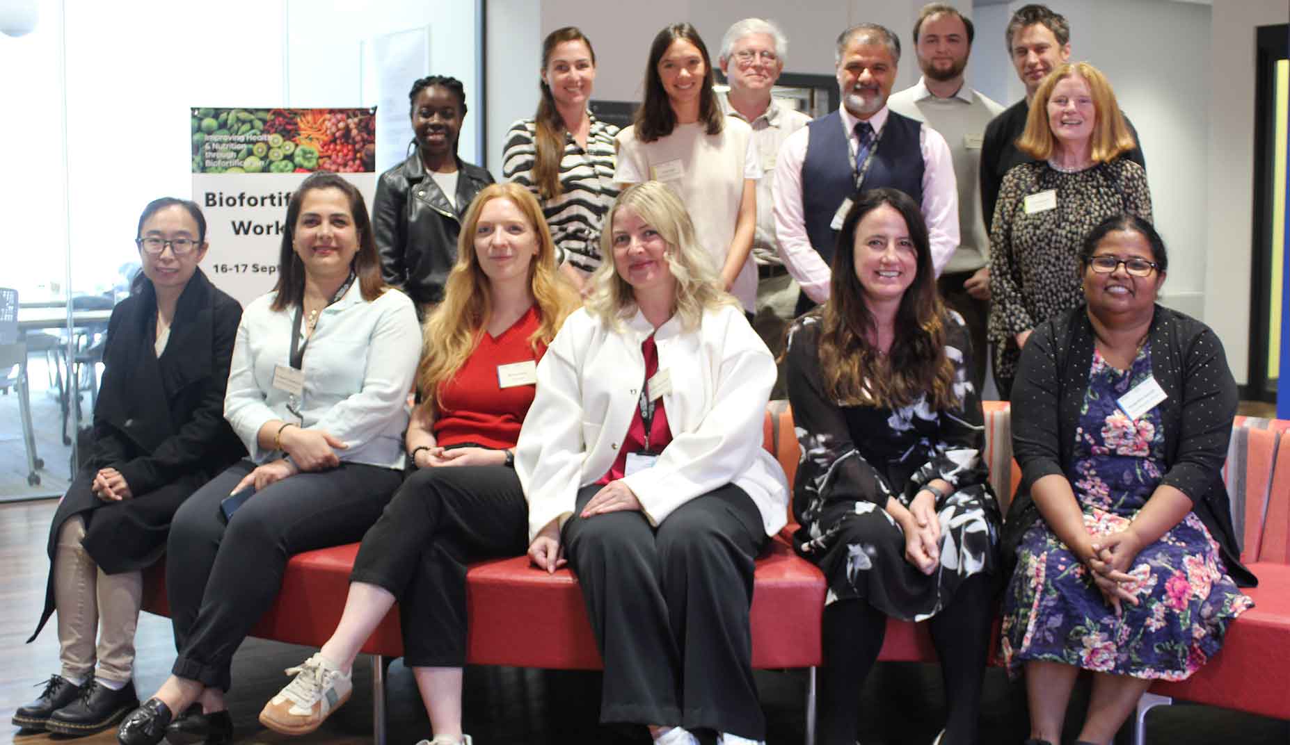 A group of people attending a workshop together smile at the camera