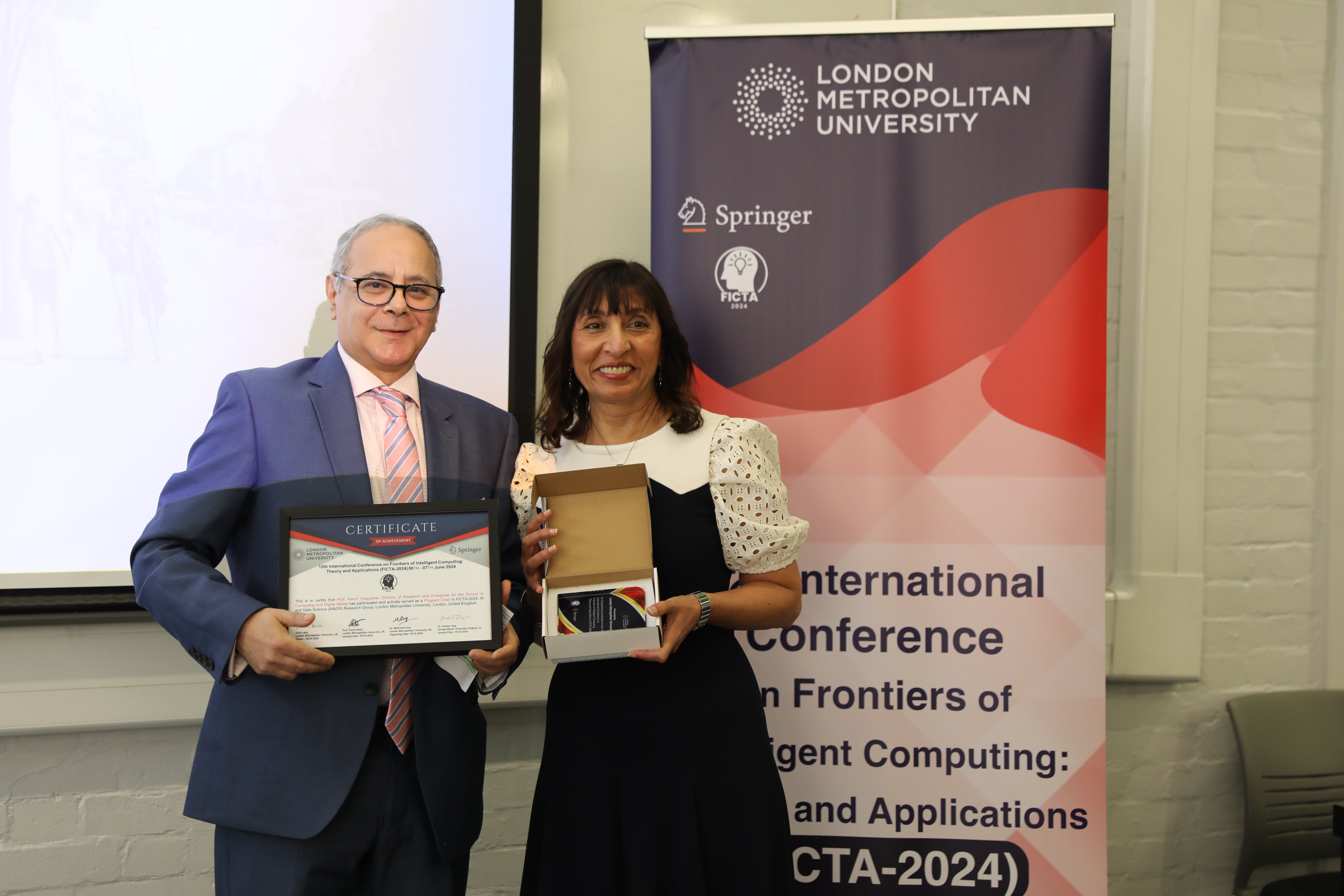 Two people holding certificates and smiling