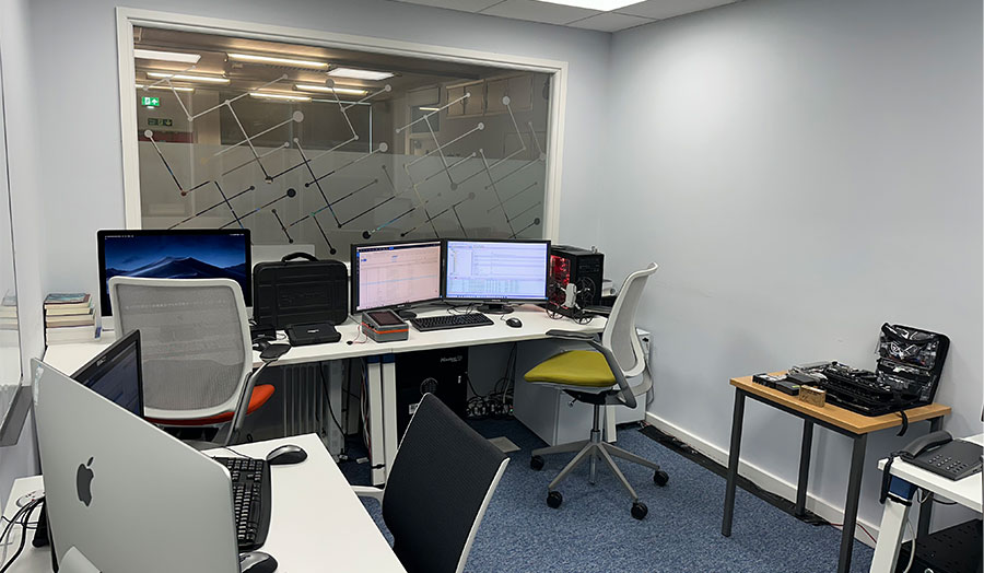 An office space with several computers, screens, and other IT equipment