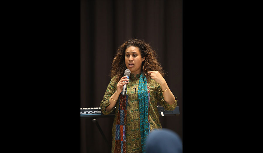 A speaker stands in front of an audience