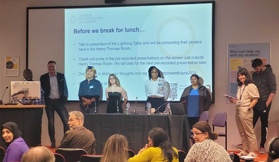 Students and staff stand on stage at a conference