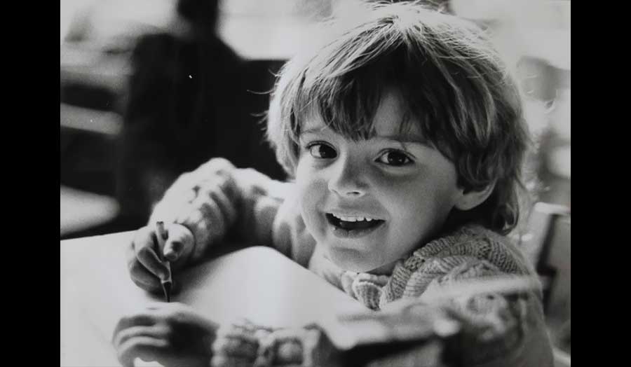 A young boy smiles at the camera
