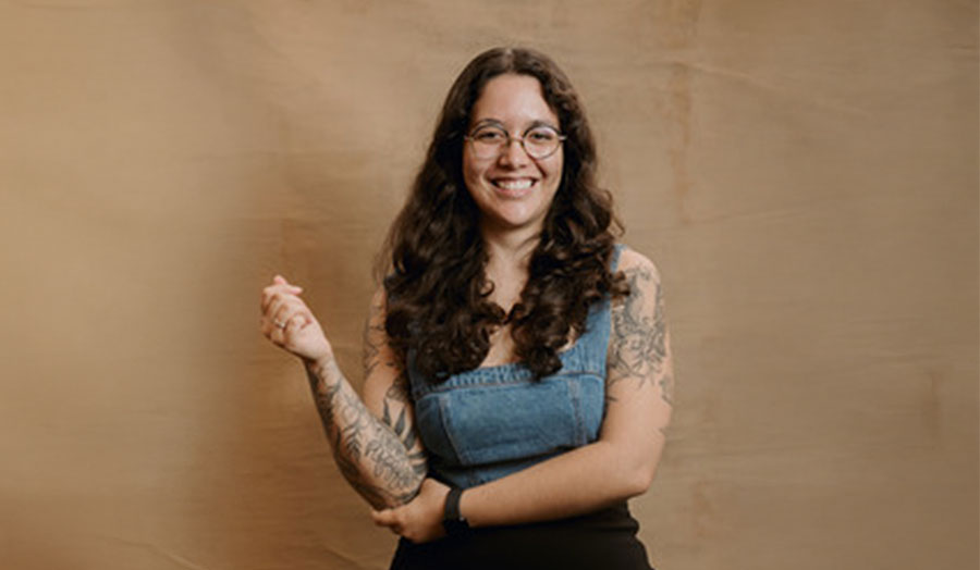 Carolina Silva smiling, with tattoos on her arms