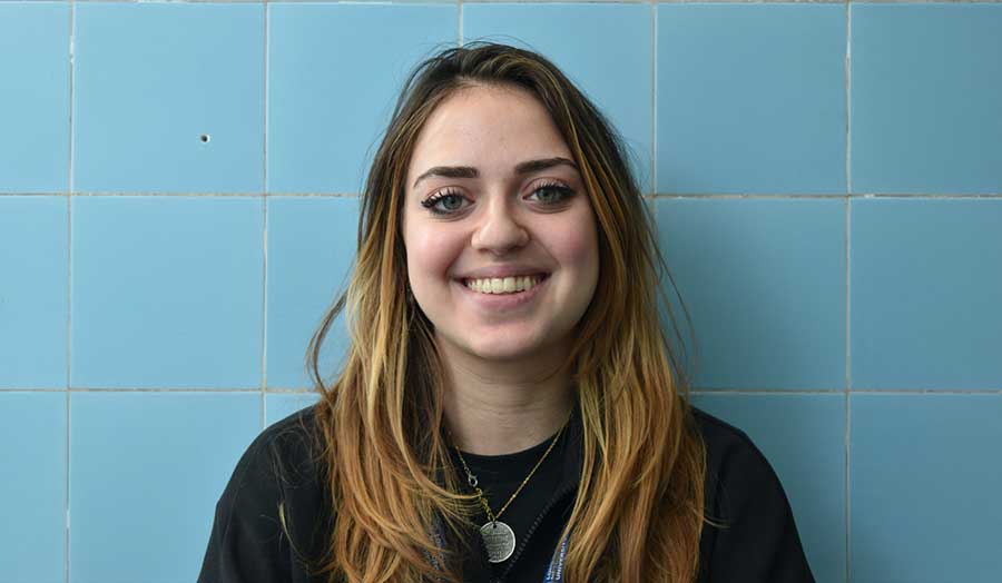 Journalism student Michelle wearing her student ID badge and smiling