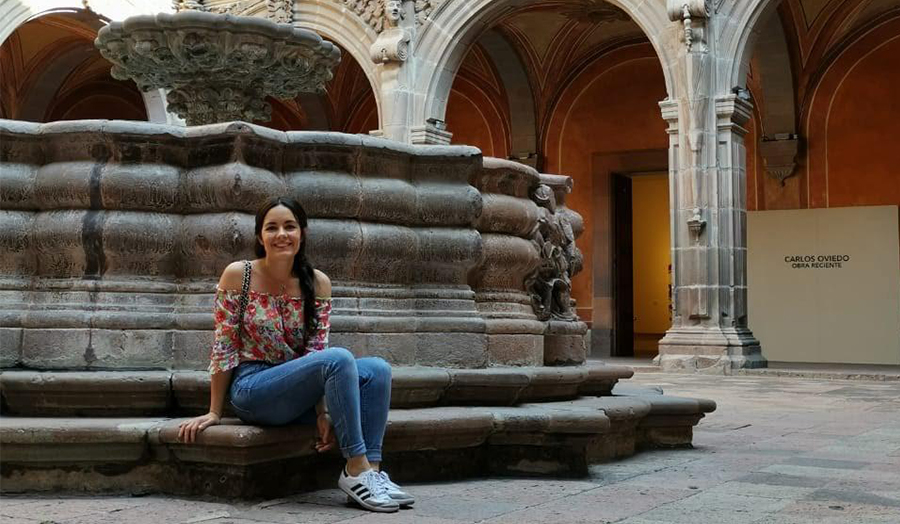 Student Paulina sitting by a grand architectural fountain